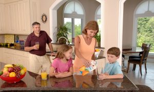 family-drinking-orange-juice-in-kitchen