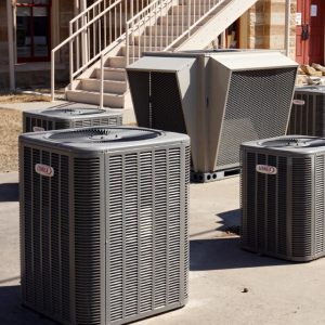 Five outdoor HVAC systems sitting outside a commercial building.